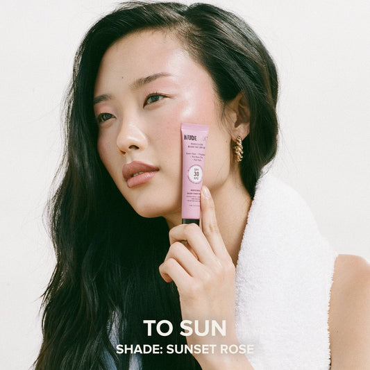 Asian young woman holding a tube of Nudescreen Blush Tint in shade SUNSET ROSE - 2