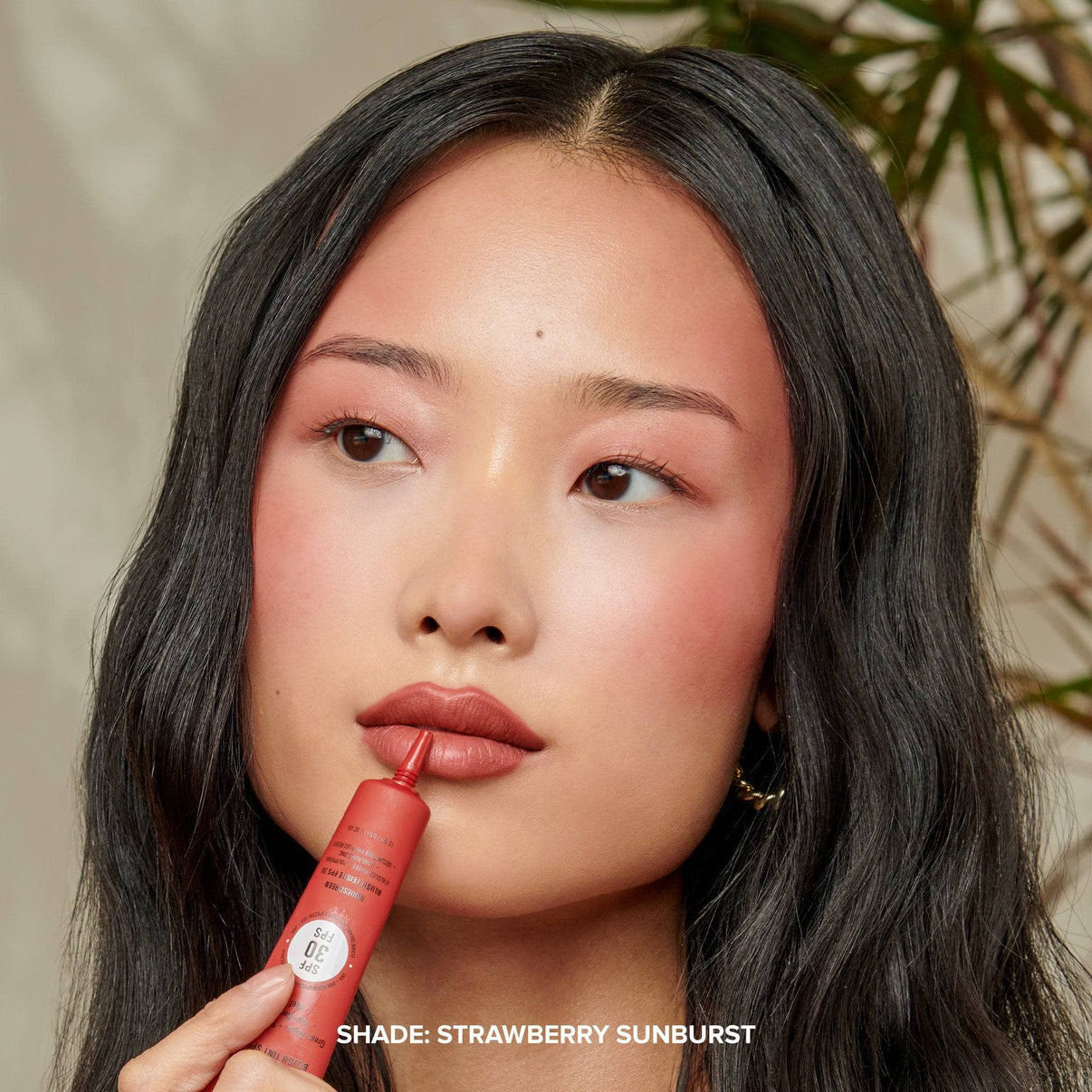 Model applying STRAWBERRY SUNBURST on her lips