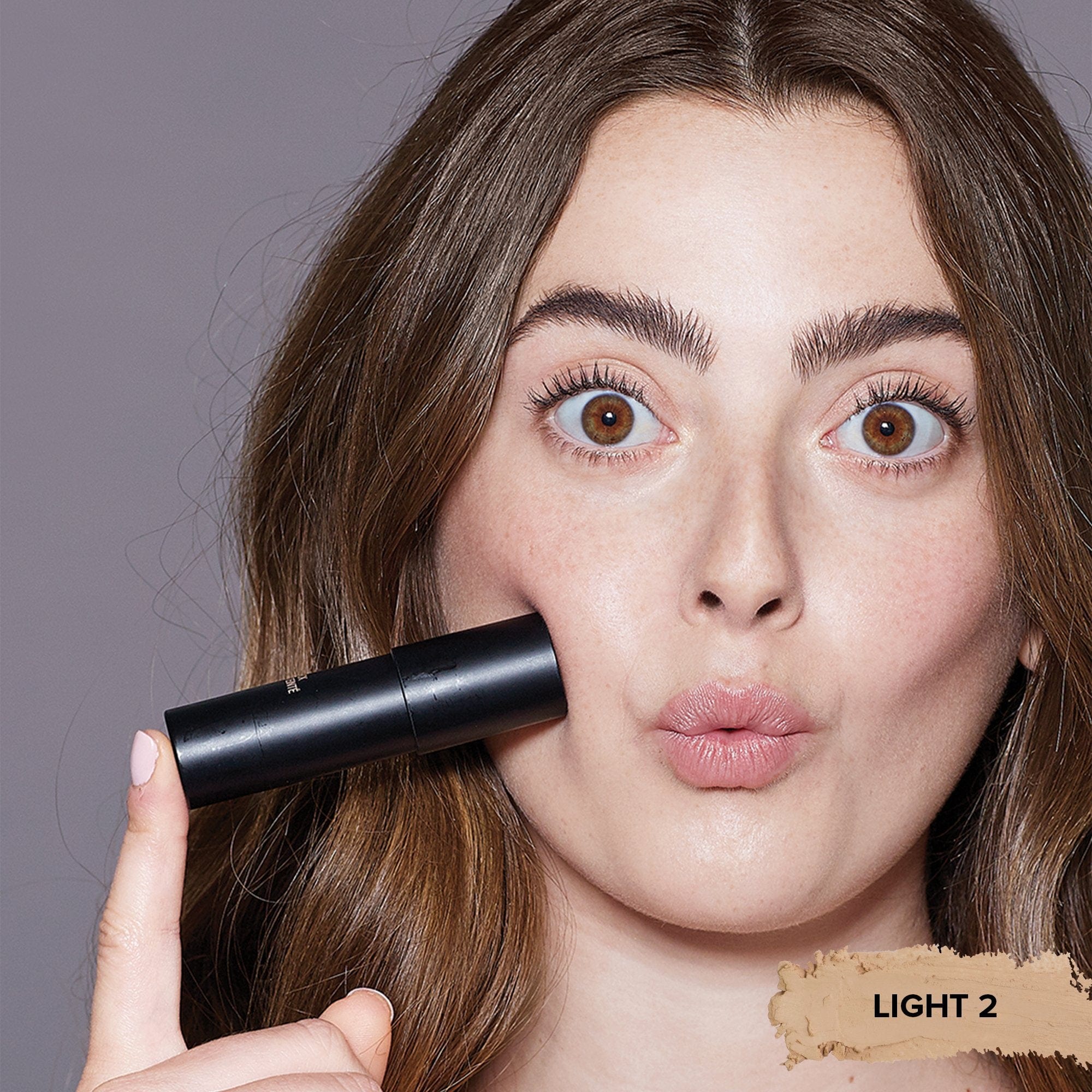 Taylor Frankel holding a Tinted Blur Foundation Stick in shade Light 2