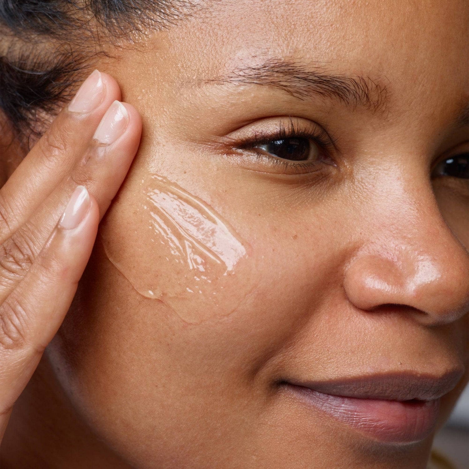 Woman applying Gentle Hydra-Gel Face Cleanser on her cheek