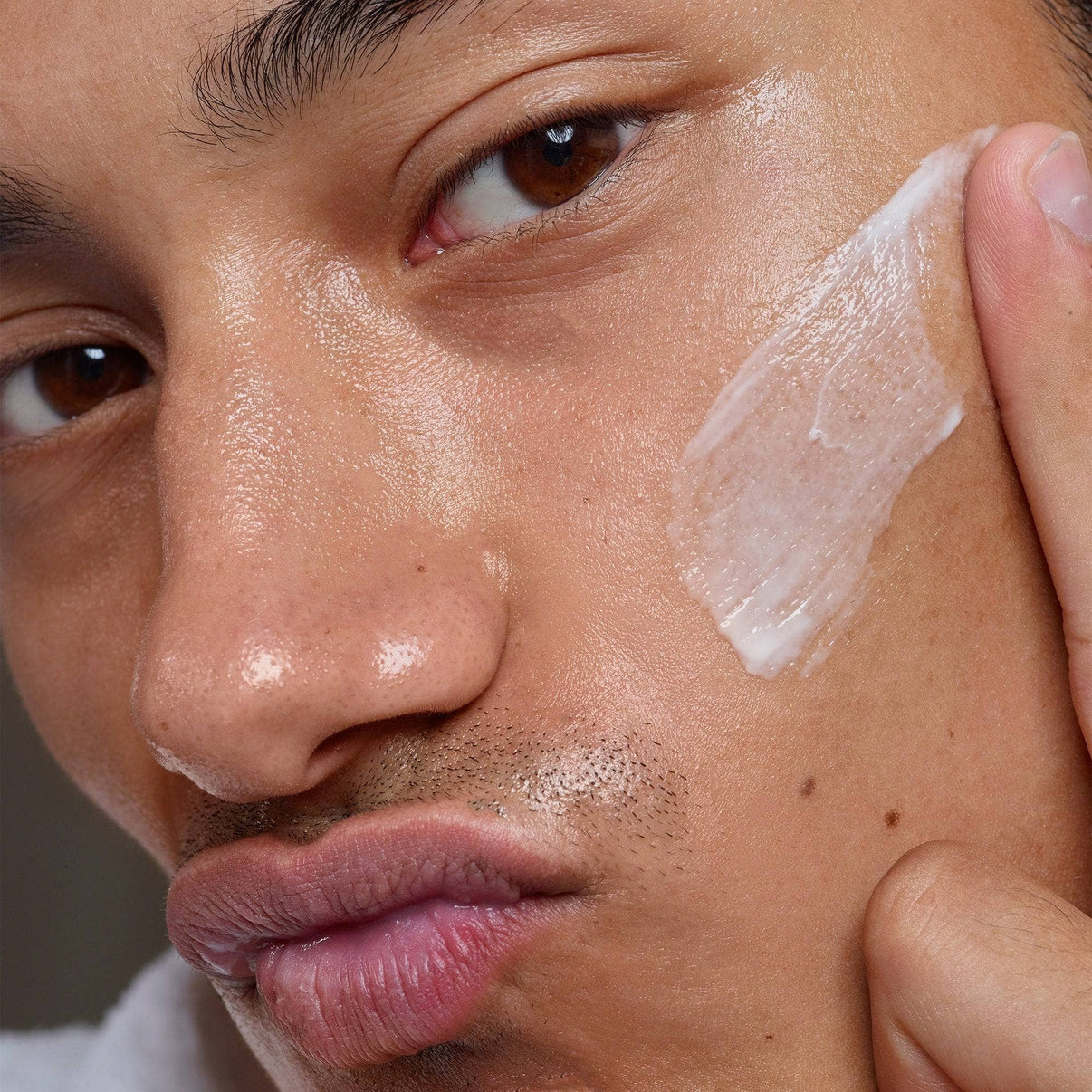 Male model applying Citrus-C Mask & Daily Moisturizer on his cheek
