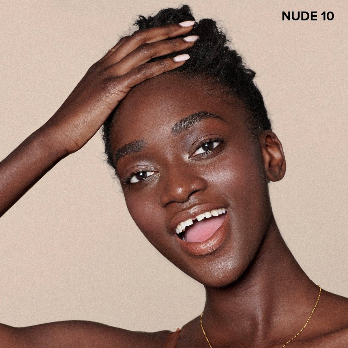 Deep skinned young woman wearing Nudefix cream concealer in shade nude 10