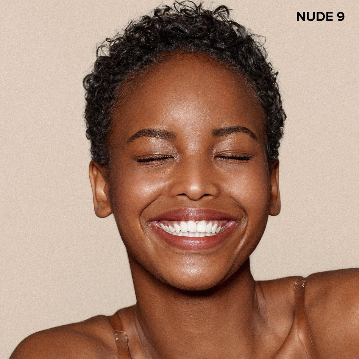 Dark skinned young woman wearing Nudefix cream concealer in shade nude 9