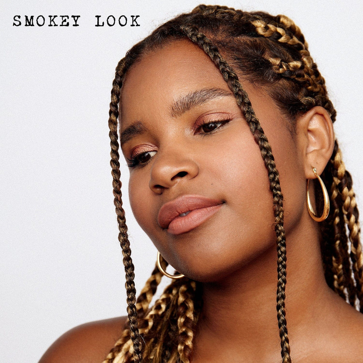 スモーキー ヌード グロー キットを使用したスモーキー ルックの浅黒い肌の若い女性